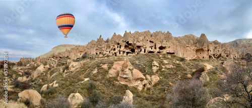 Extraordinary rocks formations rock hills and colorful balloon over zelve antique city ruins, Cappadocia, Nevsehir, Turkey
