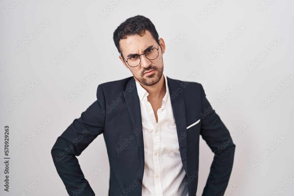 Handsome business hispanic man standing over white background skeptic and nervous, frowning upset because of problem. negative person. Handsome business hispanic man standing over white background skeptic and nervous, frowning upset because of problem. negative person.