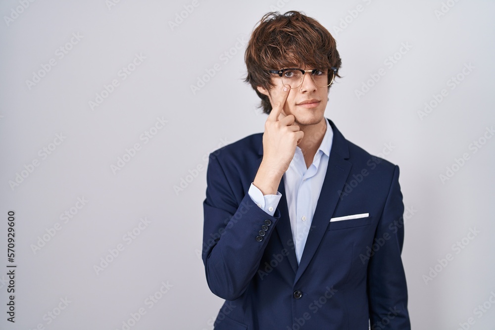 Hispanic business young man wearing glasses pointing to the eye watching you gesture, suspicious expression Hispanic business young man wearing glasses pointing to the eye watching you gesture, suspicious expression
