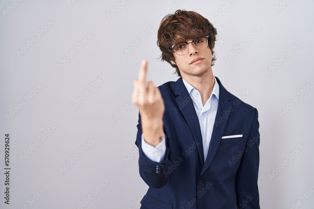 Hispanic business young man wearing glasses showing middle finger, impolite and rude fuck off expression Hispanic business young man wearing glasses showing middle finger, impolite and rude fuck off expression