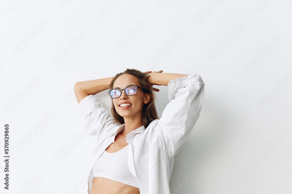 Woman portrait with tanned skin wearing vision goggles on a white background smiling with teeth and hands up in joy Woman portrait with tanned skin wearing vision goggles on a white background smiling with teeth and hands up in joy