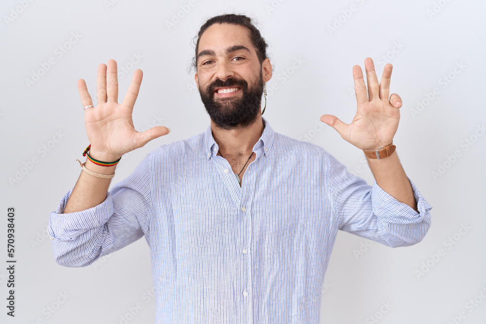 Naklejka premium Hispanic man with beard wearing casual shirt showing and pointing up with fingers number nine while smiling confident and happy.