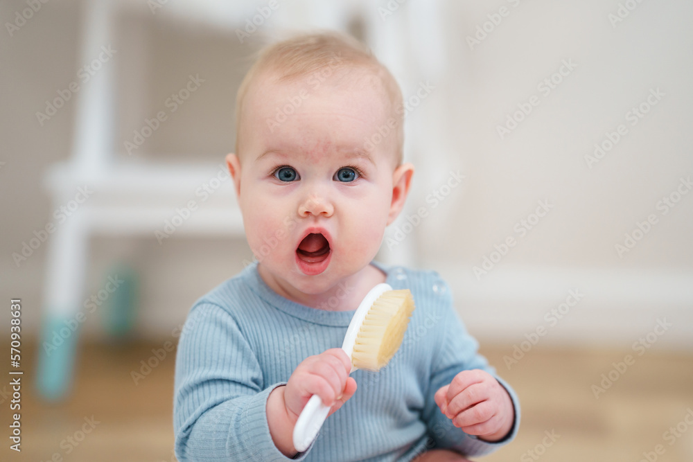 Little cute toddler baby is playing with a comb. Portrait of a child Little cute toddler baby is playing with a comb. Portrait of a child