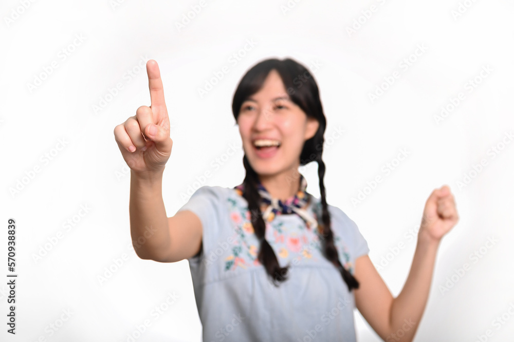 Portrait of beautiful happy young asian woman in denim dress touching invisible screen on white background. Portrait of beautiful happy young asian woman in denim dress touching invisible screen on white background.