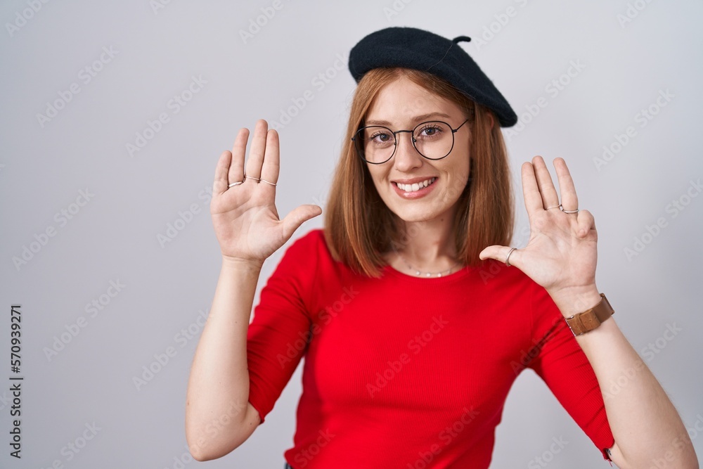 Young redhead woman standing wearing glasses and beret showing and pointing up with fingers number nine while smiling confident and happy. Young redhead woman standing wearing glasses and beret showing and pointing up with fingers number nine while smiling confident and happy.
