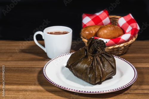Typical Colombian Tamale with chocolate and bread, traditional colombian food, white plate, copy space photo