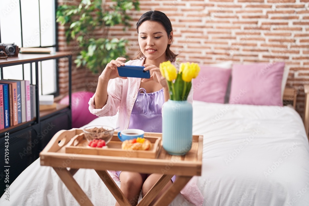 Young hispanic woman make photo by smartphone to gift breakfast at bedroom Young hispanic woman make photo by smartphone to gift breakfast at bedroom