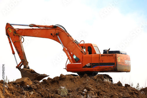Crawler excavator scoops the earth with a bucket. Earthmoving works, digging and construction industry