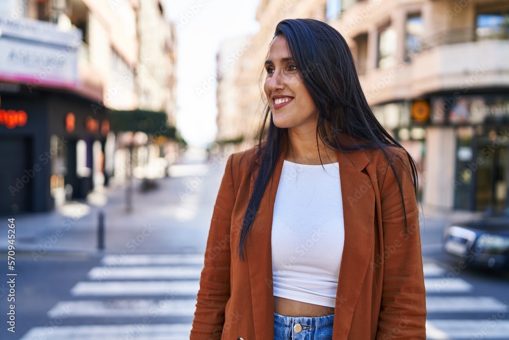 Young hispanic woman smiling confident walking at street