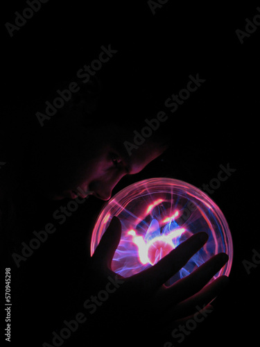 A young guy ducked his head in front of a plasma ball 