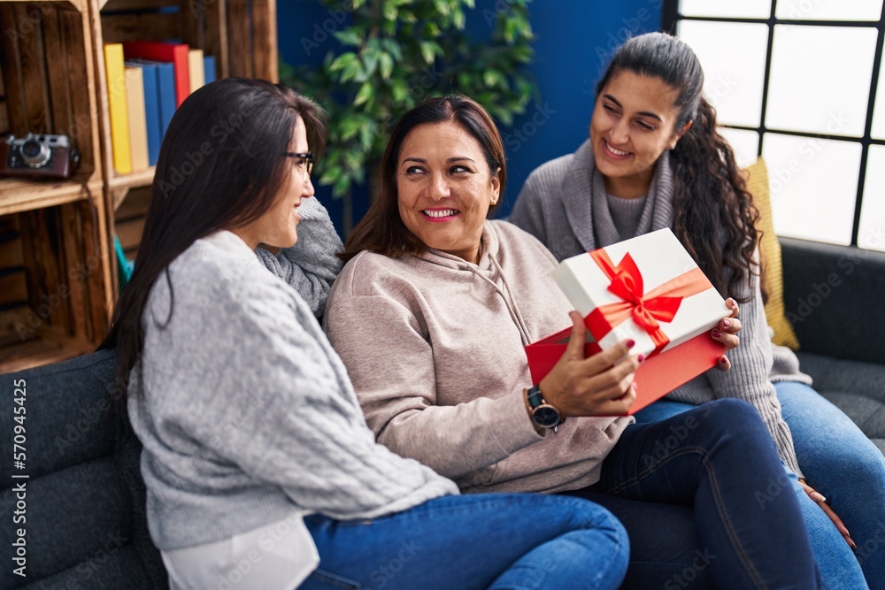 Three woman surprise with gift sitting on sofa at home Three woman surprise with gift sitting on sofa at home