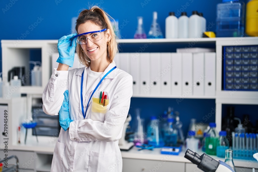 Young woman scientist smiling confident standing at laboratory Young woman scientist smiling confident standing at laboratory