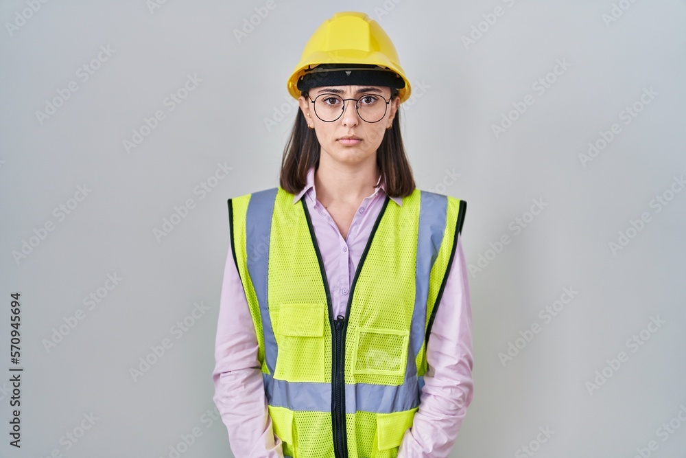 Hispanic girl wearing builder uniform and hardhat skeptic and nervous, frowning upset because of problem. negative person. Hispanic girl wearing builder uniform and hardhat skeptic and nervous, frowning upset because of problem. negative person.