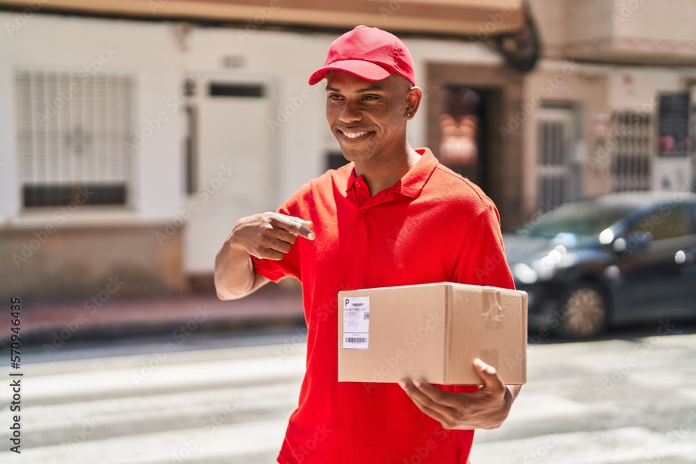 Young latin man delivery worker pointing with finger to package at street Young latin man delivery worker pointing with finger to package at street