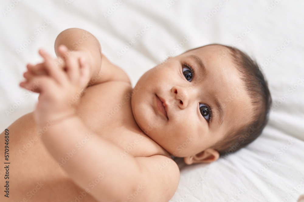 Adorable hispanic baby lying on bed at bedroom Adorable hispanic baby lying on bed at bedroom