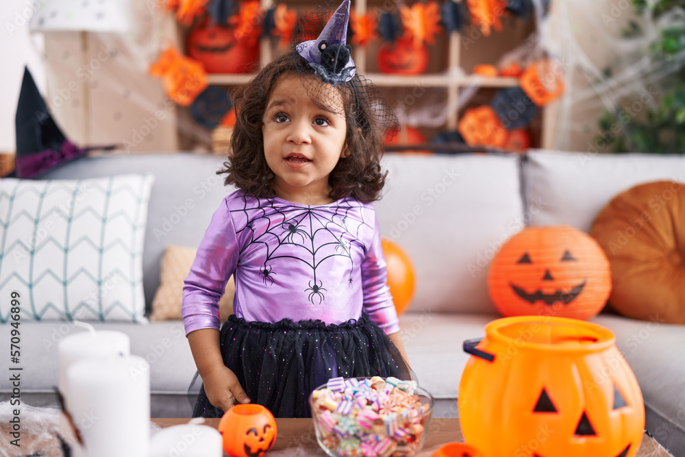 Fototapeta premium Adorable hispanic toddler having halloween party standing at home