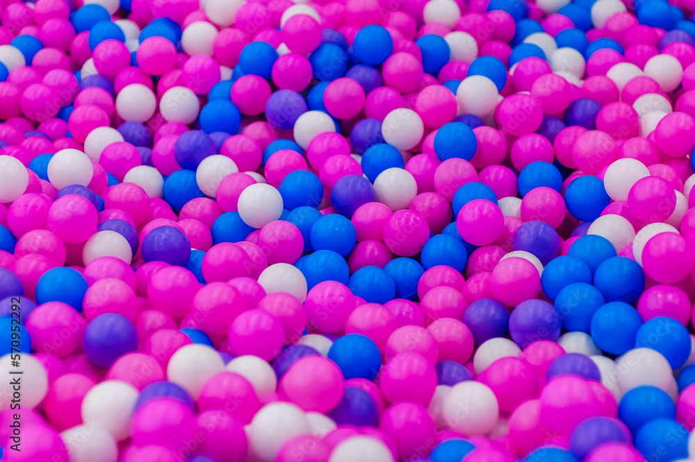 Background, closeup texture of colored, multi-colored round plastic small balls on the playground for children's games. Photo, top view, copy space.