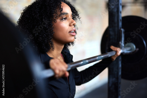 Fit woman standing with weights in a gym photo