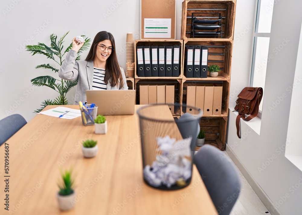 Young beautiful hispanic woman business worker throwing crumpled paper on paper bin at office Young beautiful hispanic woman business worker throwing crumpled paper on paper bin at office