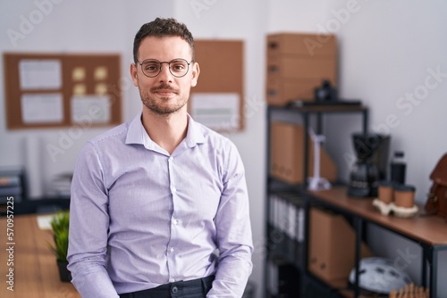Young hispanic man at the office relaxed with serious expression on face. simple and natural looking at the camera.
