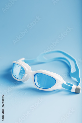 White swimming goggles on a blue background