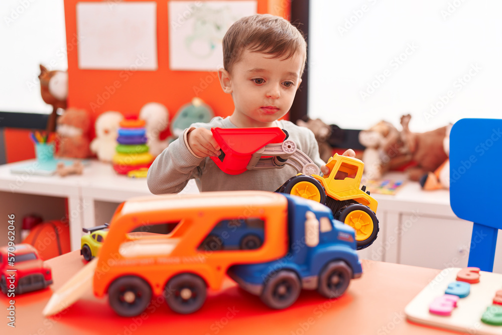 Adorable hispanic boy playing with truck toy at kindergarten Adorable hispanic boy playing with truck toy at kindergarten