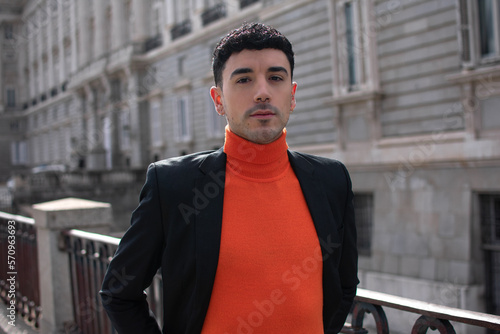 Successful young businessman in suit standing outside office with hands crossed in the street