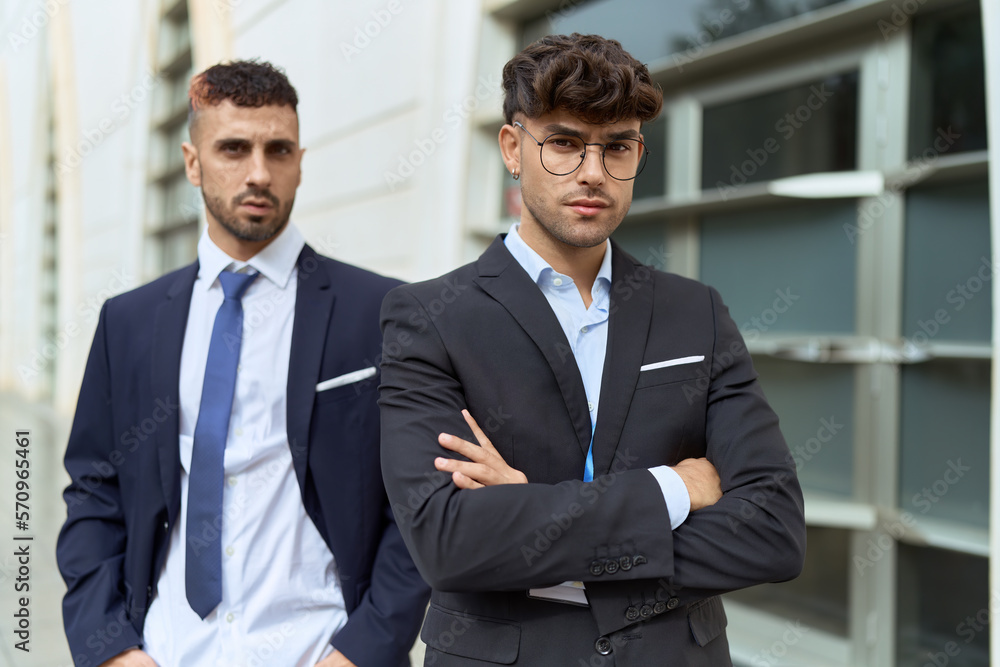 Two hispanic men business workers standing with arms crossed gesture at street Two hispanic men business workers standing with arms crossed gesture at street