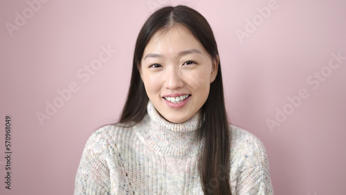 Young chinese woman smiling confident standing over isolated pink background