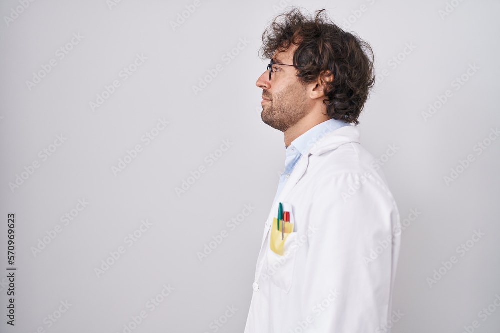 Hispanic young man wearing doctor uniform looking to side, relax profile pose with natural face with confident smile. Hispanic young man wearing doctor uniform looking to side, relax profile pose with natural face with confident smile.