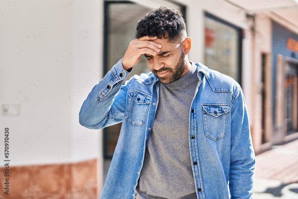 Young hispanic man suffering for headache at street Young hispanic man suffering for headache at street