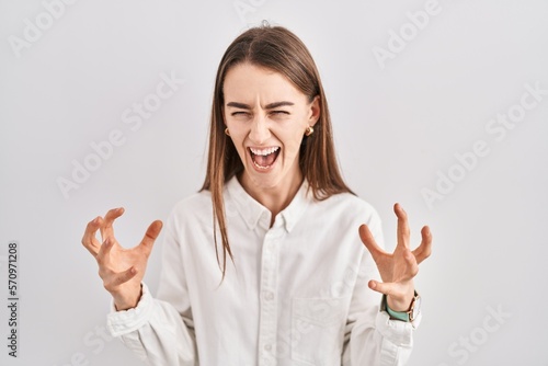 Wallpaper Mural Young caucasian woman standing over isolated background crazy and mad shouting and yelling with aggressive expression and arms raised. frustration concept. Torontodigital.ca