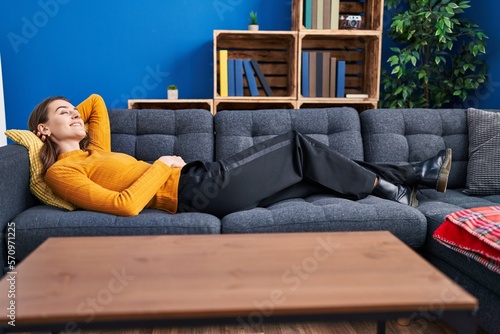 Young caucasian woman smiling confident lying on sofa at home