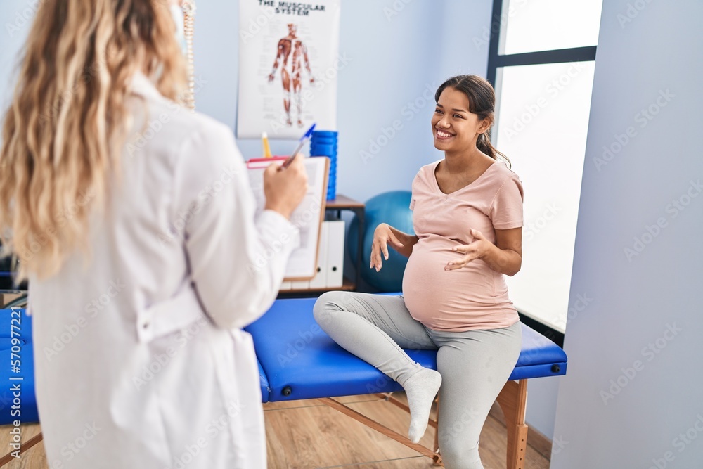 Fototapeta premium Young latin woman pregnant patient having physiotherapy session at clinic