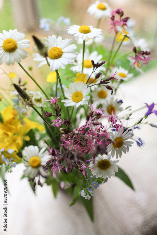 Bouquet of wild flowers in a vase on a wooden window sill. Still life on the window of an old country house, summer cottage.selective focus Bouquet of wild flowers in a vase on a wooden window sill. Still life on the window of an old country house, summer cottage.selective focus