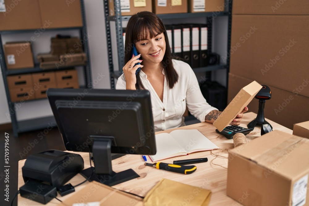 Young beautiful hispanic woman ecommerce business worker talking on smartphone holding package at office Young beautiful hispanic woman ecommerce business worker talking on smartphone holding package at office