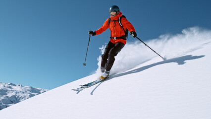 Free ride skier running down the hill.