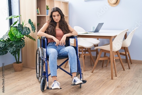 Obraz na plátně Young teenager girl sitting on wheelchair at the living room thinking attitude a