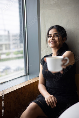 beautiful young woman drinking her Morning coffee by the window with a bright smile Free Download beautiful young woman drinking her Morning coffee by the window with a bright smile - GFXLoad
