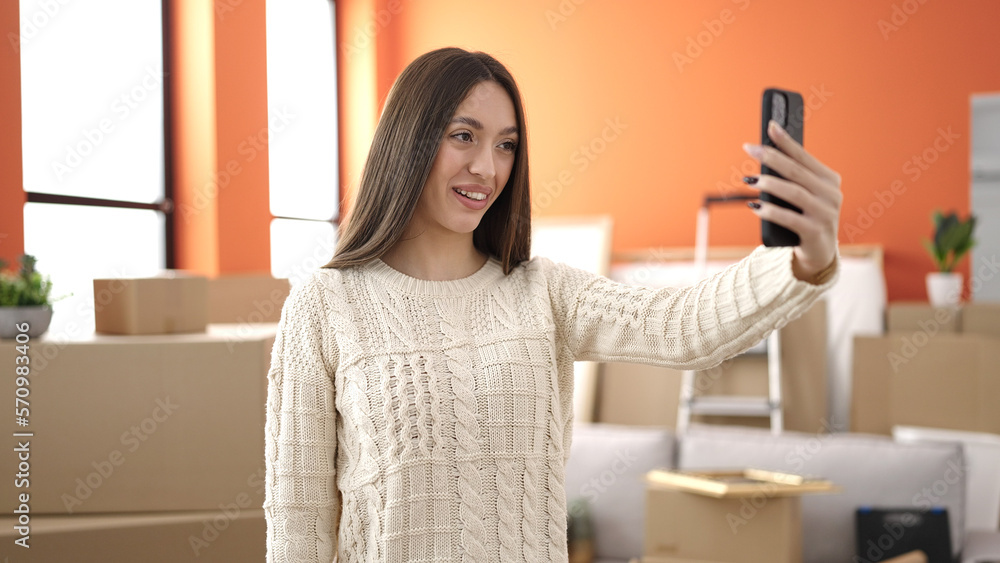 Young beautiful hispanic woman make selfie by smartphone standing at new home Young beautiful hispanic woman make selfie by smartphone standing at new home
