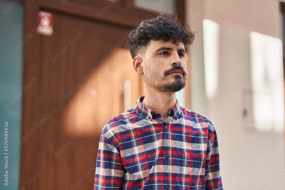 Young hispanic man looking to the side with relaxed expression at street Young hispanic man looking to the side with relaxed expression at street