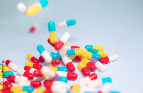 Creative layout of colorful pills and capsules on blue background. Minimal medical concept. Pharmaceutical, Medicine. Flat lay, top view.