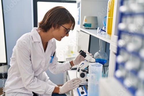 Wallpaper Mural Young beautiful hispanic woman scientist using microscope at laboratory Torontodigital.ca