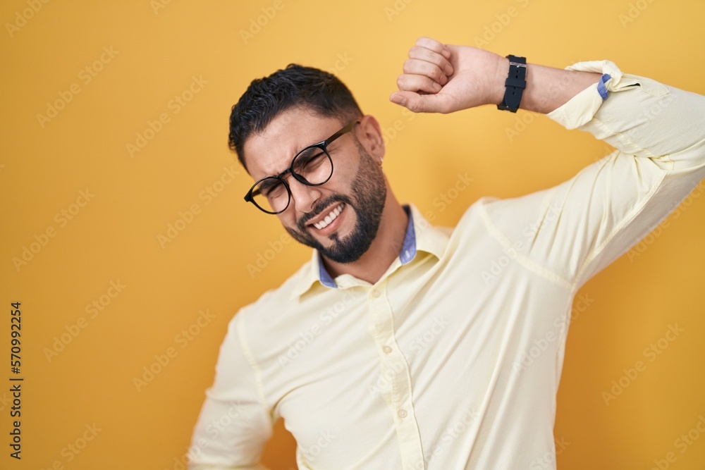 Hispanic young man wearing business clothes and glasses stretching back, tired and relaxed, sleepy and yawning for early morning Hispanic young man wearing business clothes and glasses stretching back, tired and relaxed, sleepy and yawning for early morning
