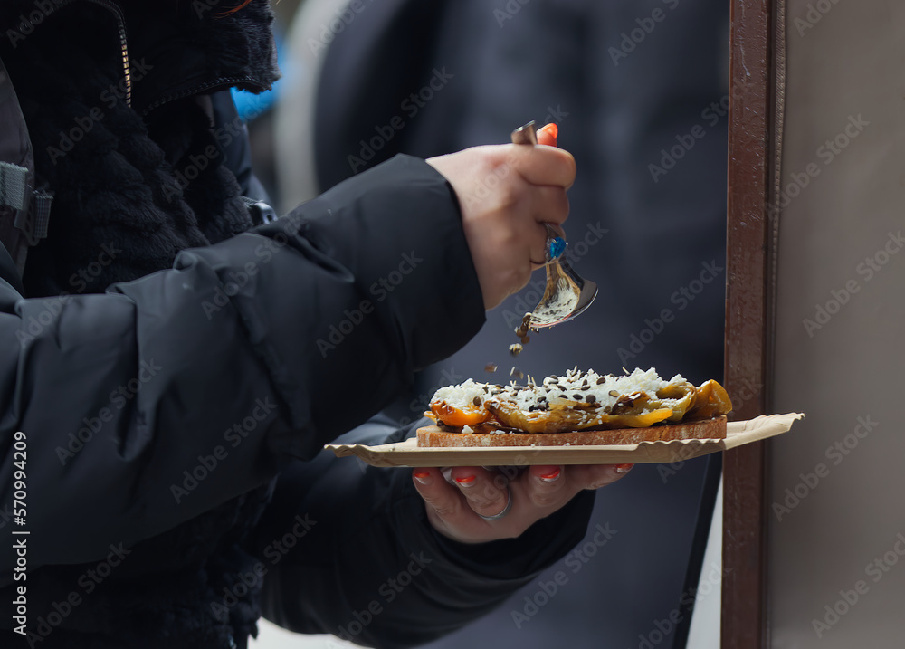A customer at the Naplavka winter farmers market in Prague seasoning her toast.
