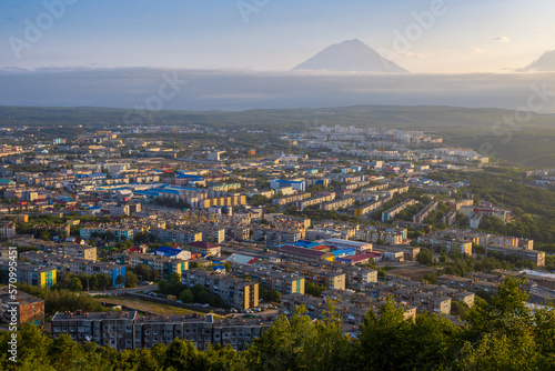 Morning cityscape. Top view of the buildings and streets of the city. Residential urban areas at sunrise. Koryaksky volcano in the distance. Petropavlovsk-Kamchatsky, Kamchatka Krai, Russian Far East.