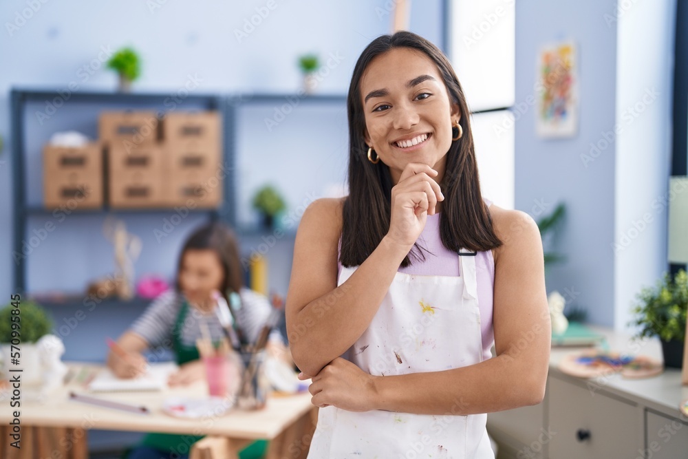 Young woman at art studio smiling looking confident at the camera with crossed arms and hand on chin. thinking positive. Young woman at art studio smiling looking confident at the camera with crossed arms and hand on chin. thinking positive.