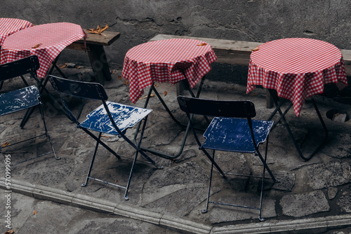 street cafe with blue chairs and tables with a red checkered tablecloth