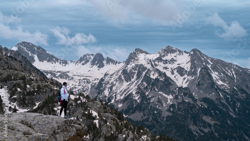 Woman with backpack with her back to the mountain peaks of Huesca, Spain