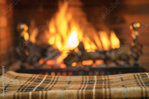 Blanket to keep warm in front of the cozy fire of the fireplace inside the house.